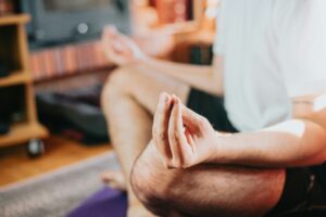 Man meditating on floor with legs crossed by Ave Calver-Unsplash+